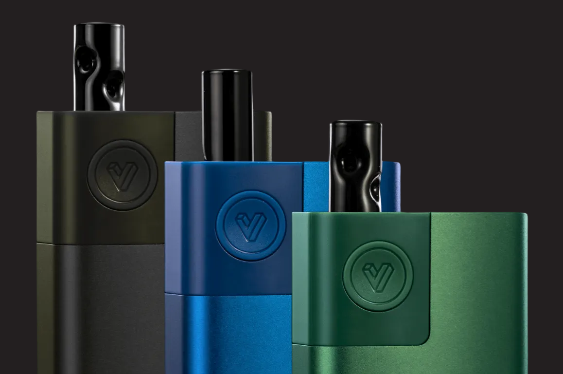 Three Lobo vape devices in matte black, metallic blue, and metallic green, arranged in a row against a dark background.